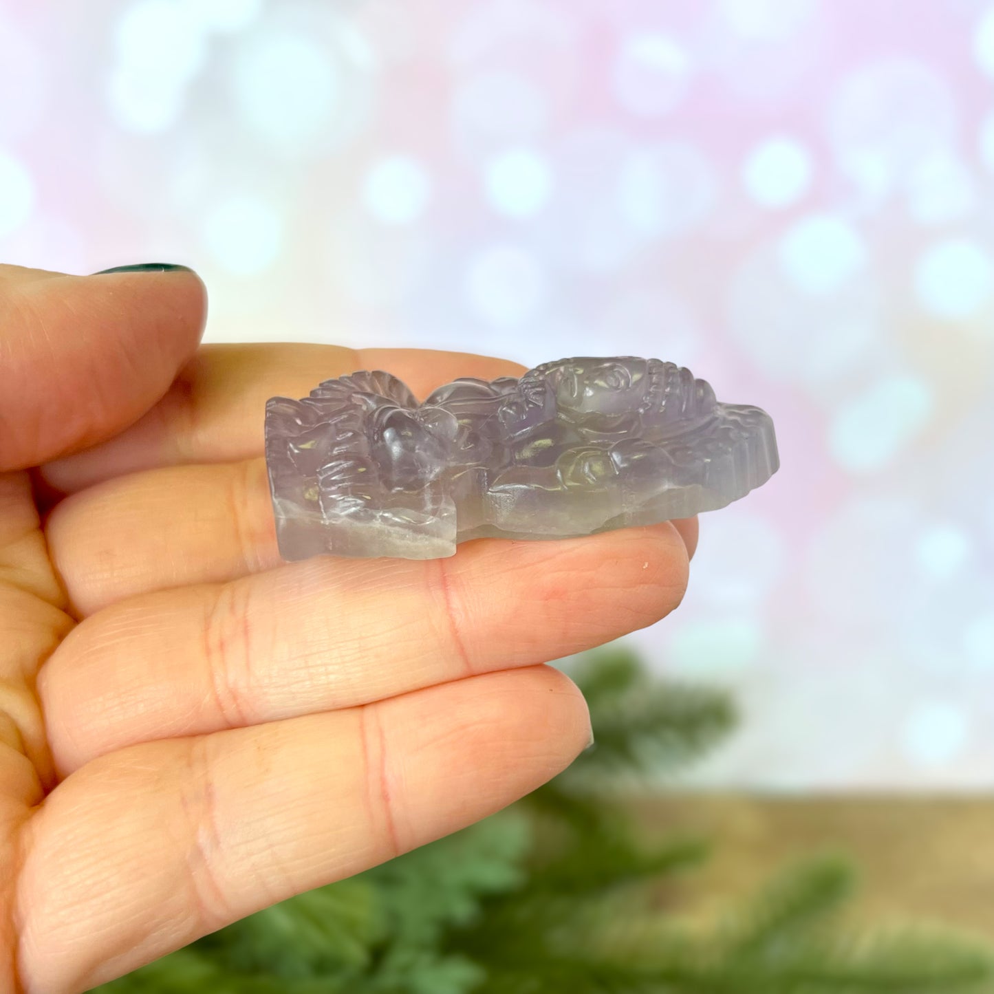 a hand holding a small piece of crystal