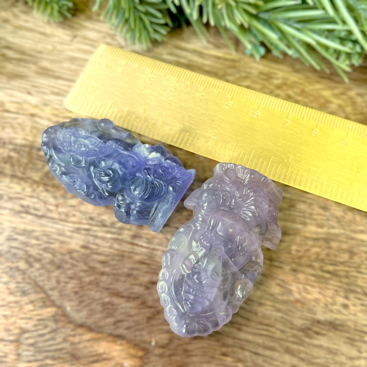 two pieces of carved glass sitting next to a ruler