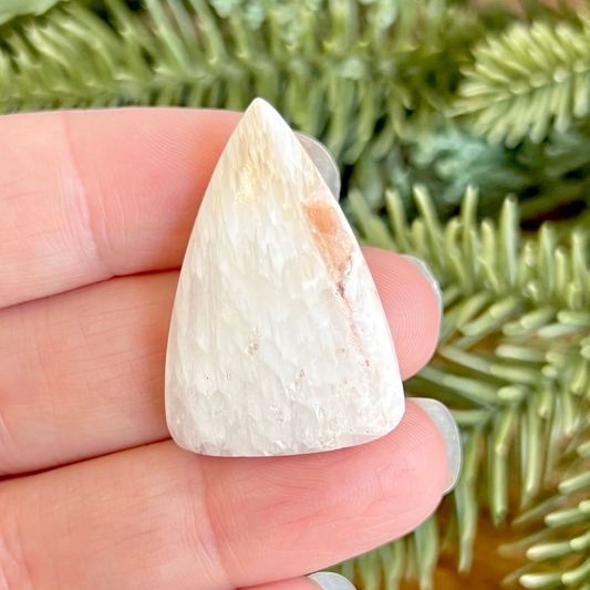 a person holding a piece of white rock in their hand