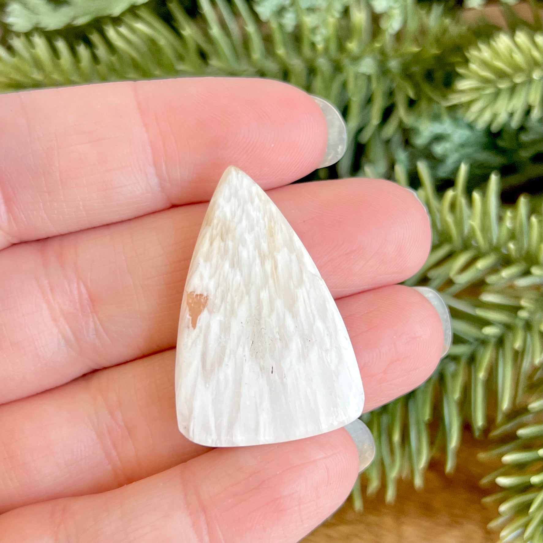 a person is holding a small white stone