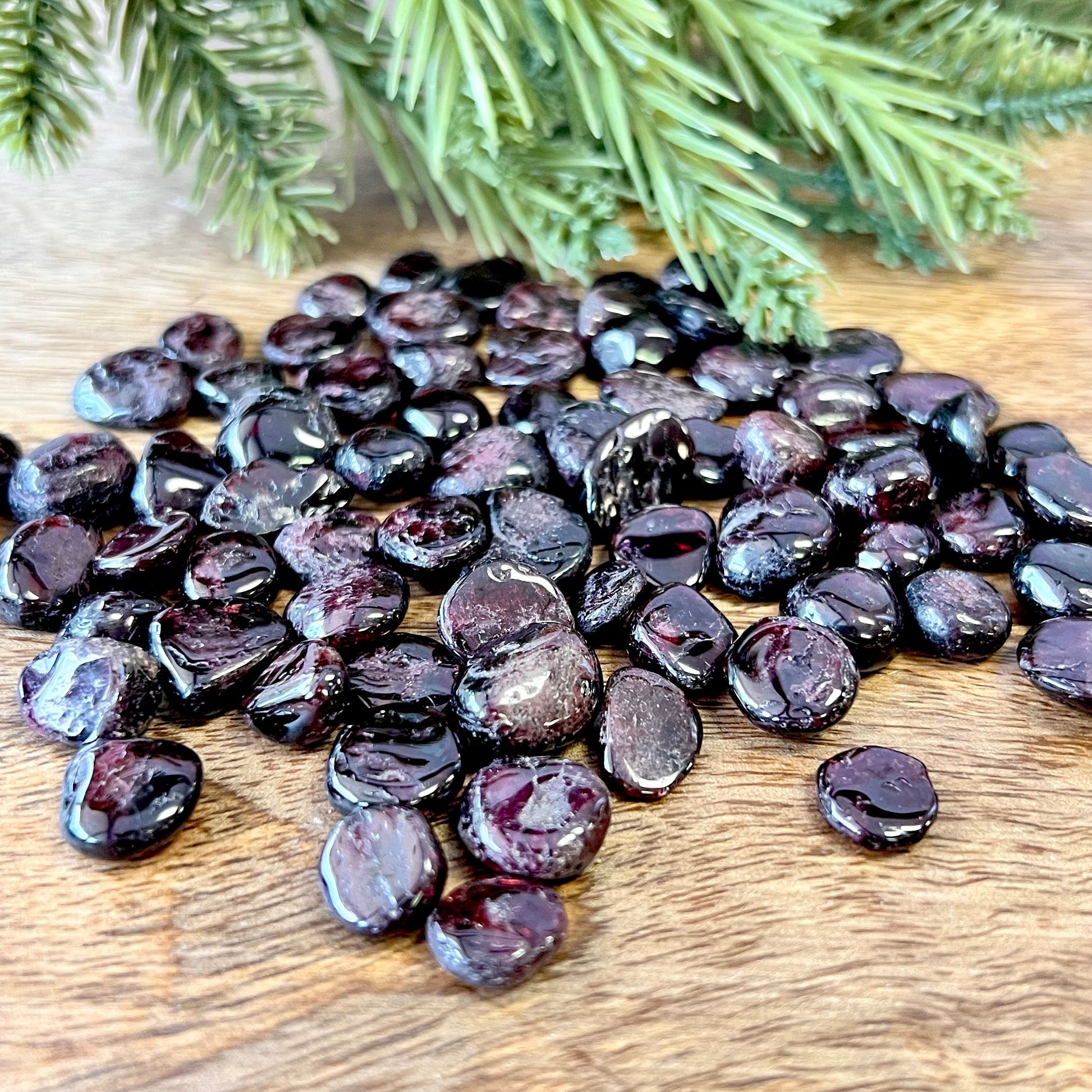 Group of small miniature tumbled crystals. They are a dark red garnet, and similar to crystal chips.