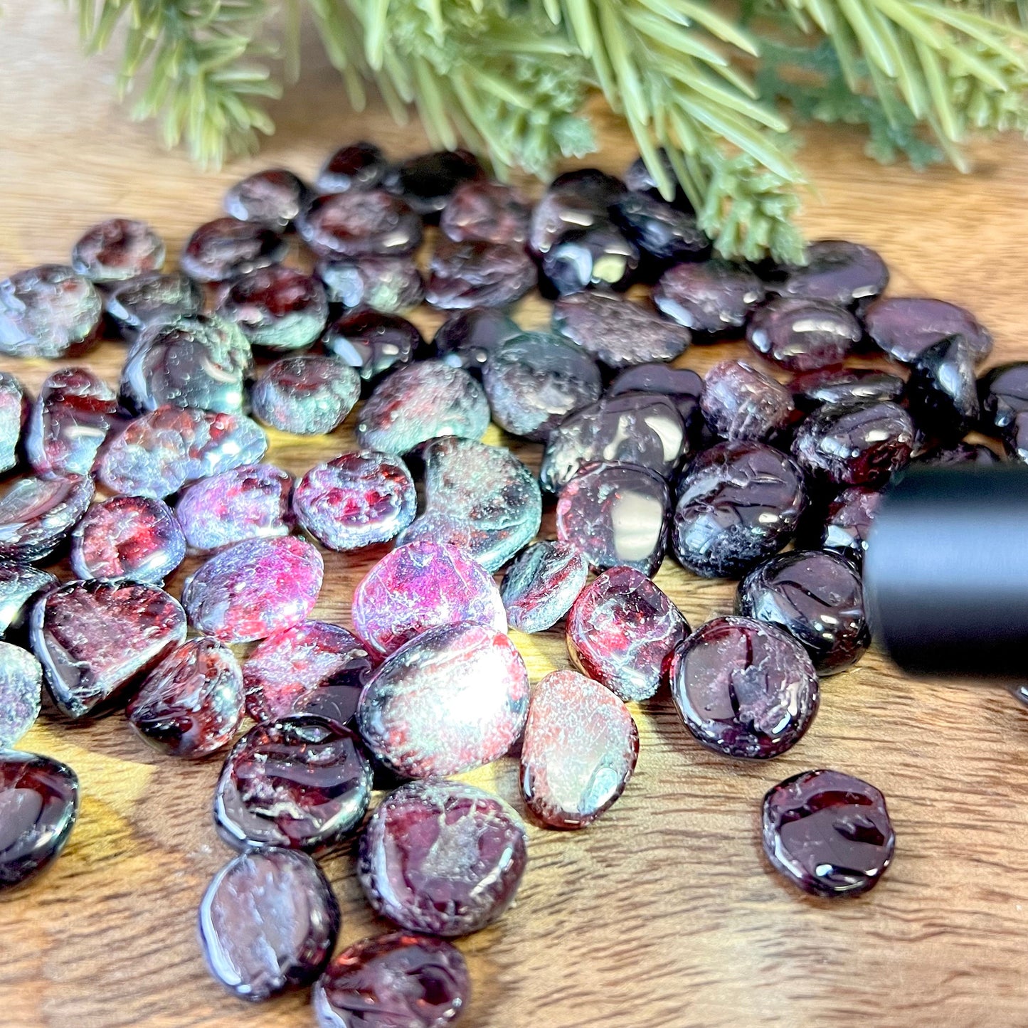 Group of small miniature tumbled crystals. They are a dark red garnet, and similar to crystal chips.