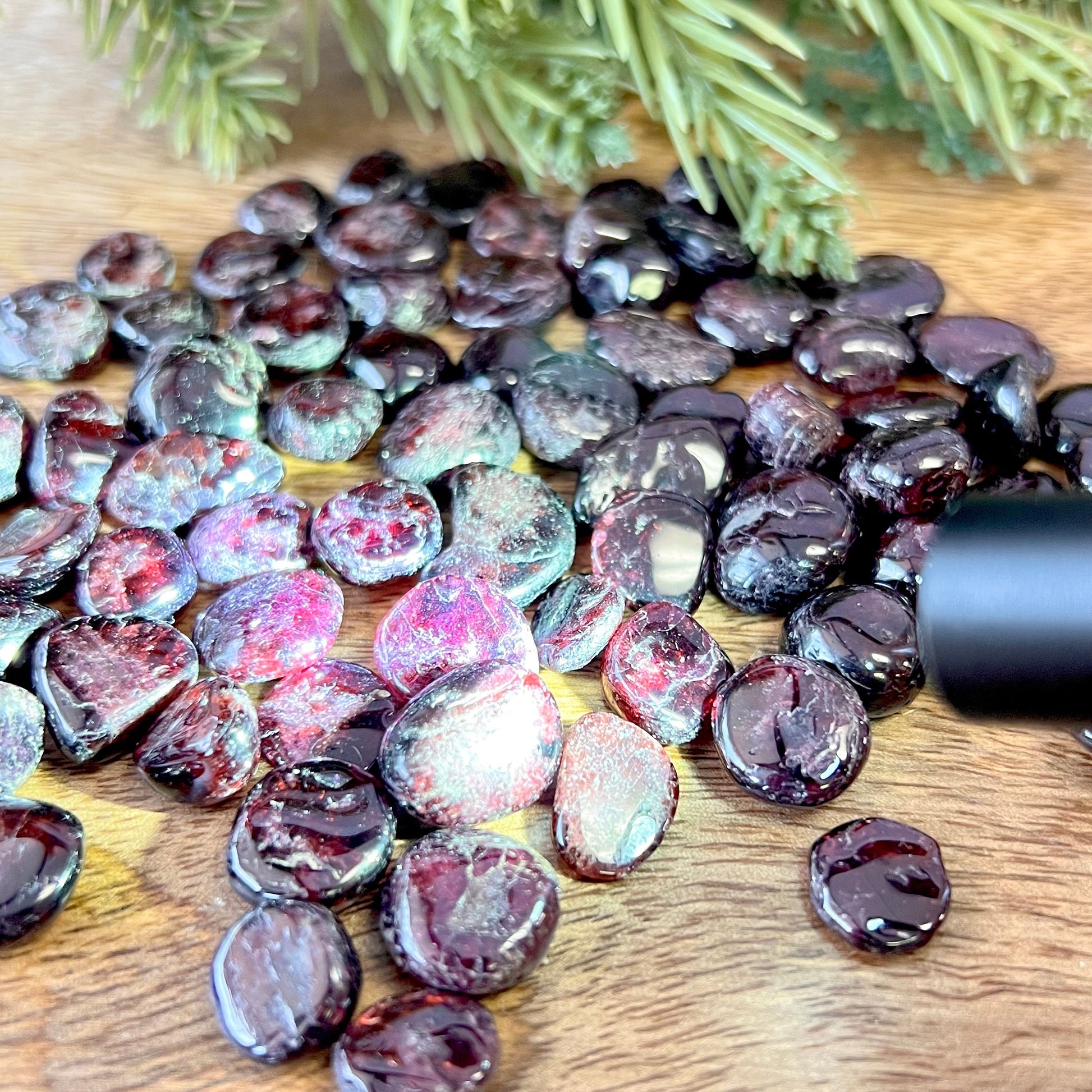 Group of small miniature tumbled crystals. They are a dark red garnet, and similar to crystal chips.