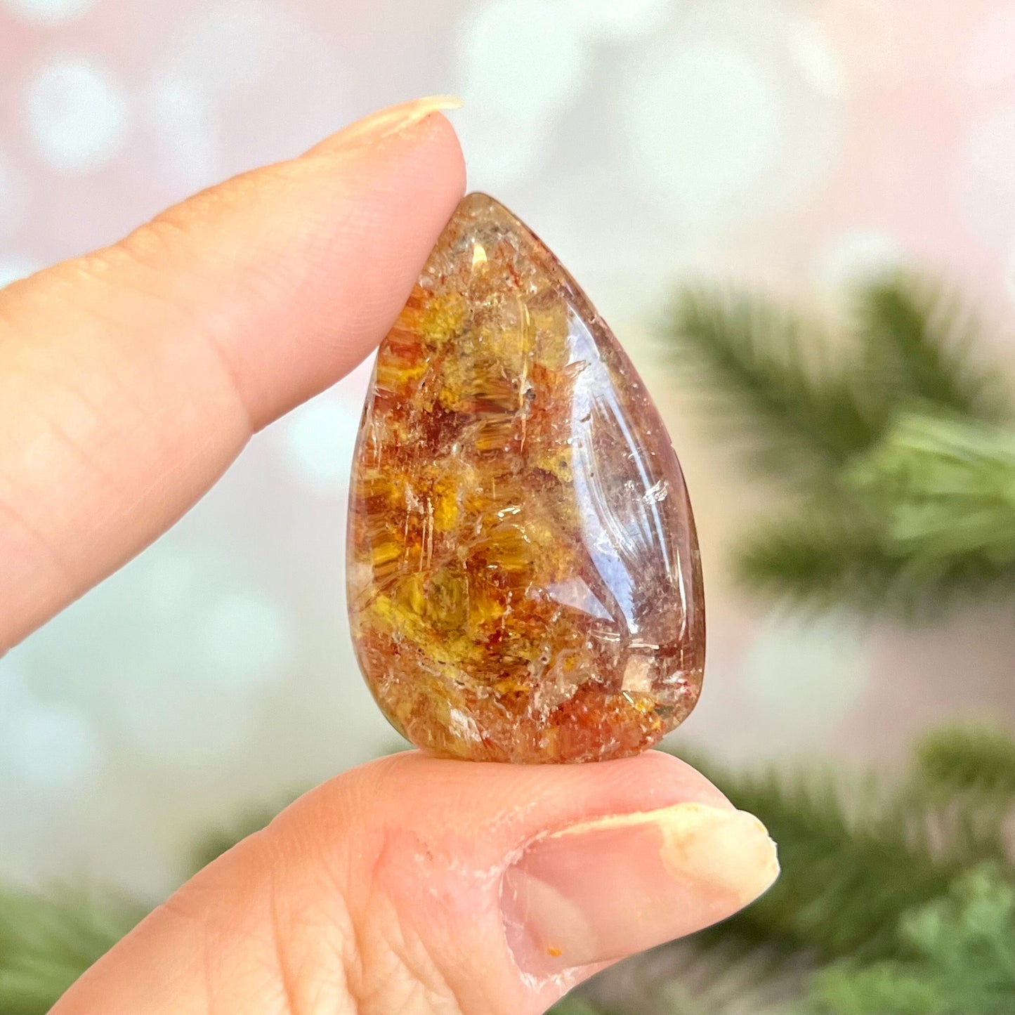 Garden Quartz polished teardrop crystal. Lodolite tumbled stone with rutilated quartz that's been dyed bright red and yellow colors