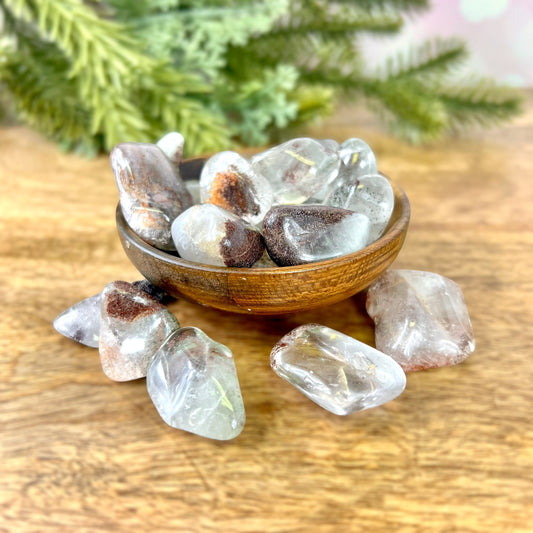a wooden bowl filled with lodolite Garden Quartz tumbled crystals