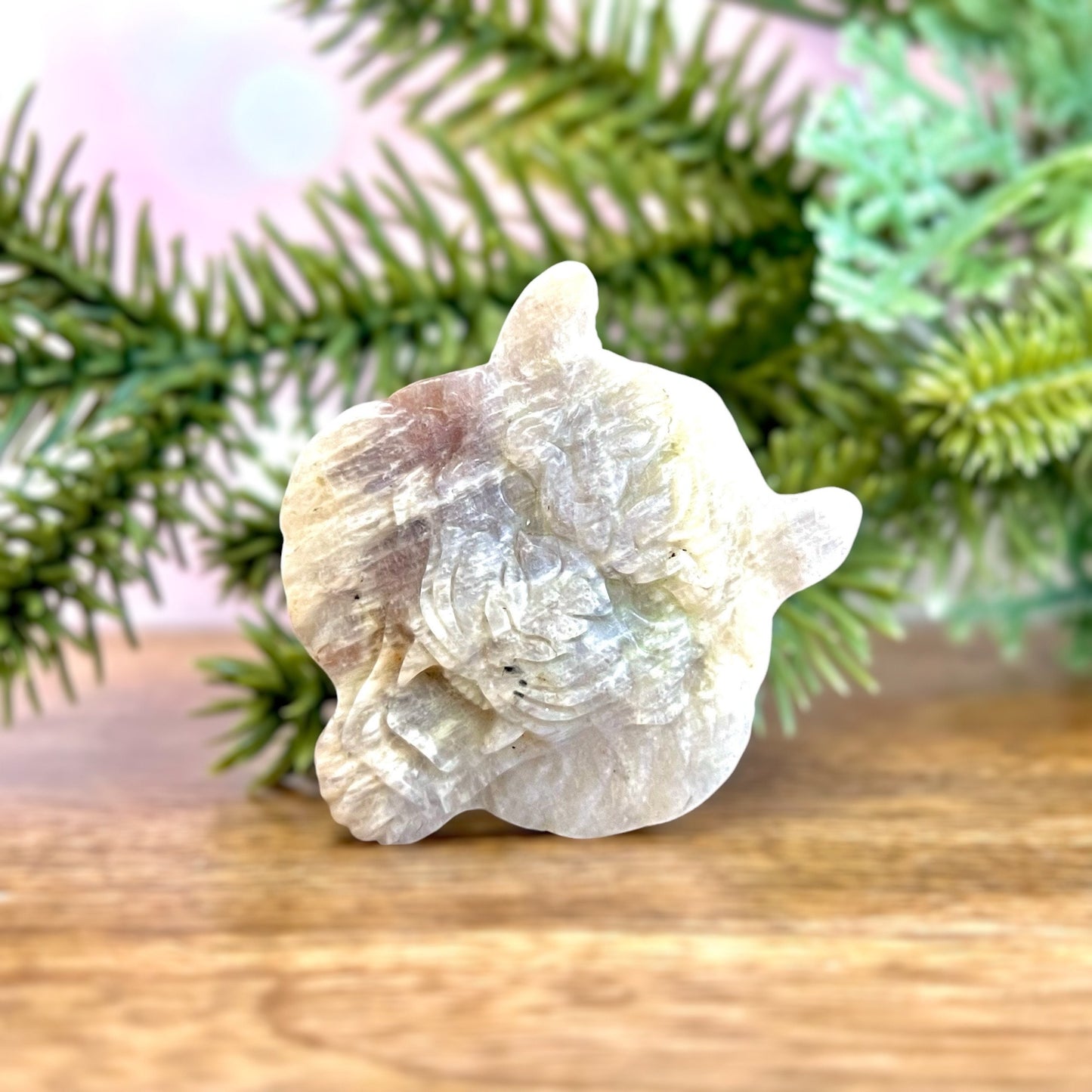 Sunstone in Moonstone carved crystal in the shape of a roaring tiger's head. Mostly off white color with hints of orange and blue flash