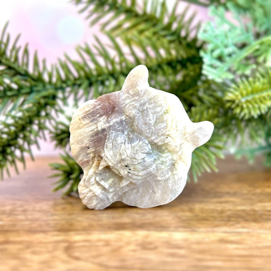 Sunstone in Moonstone carved crystal in the shape of a roaring tiger's head. Mostly off white color with hints of orange and blue flash