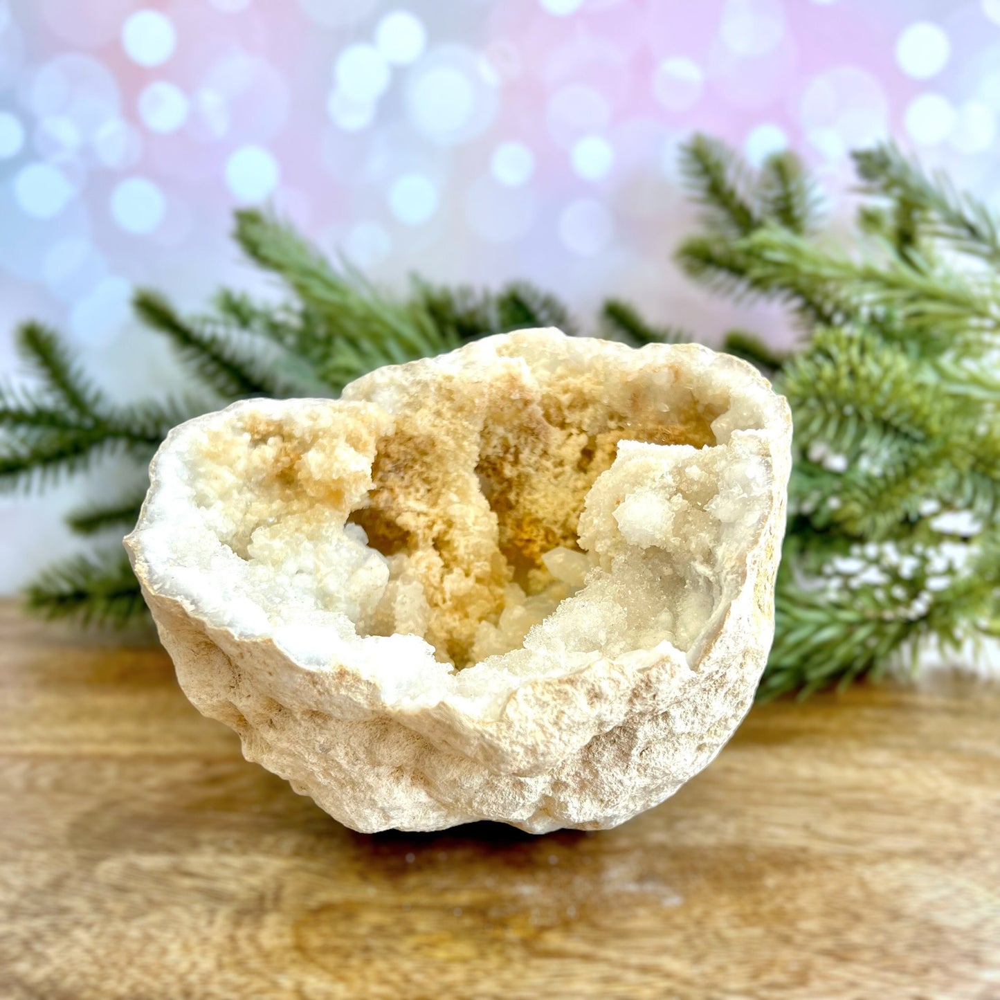 Image of a large Quartz sugar geode from Morocco. Has a sandy beige exterior, and lots of small, white crystals on the inside. Has some pale yellow iron staining on some crystals