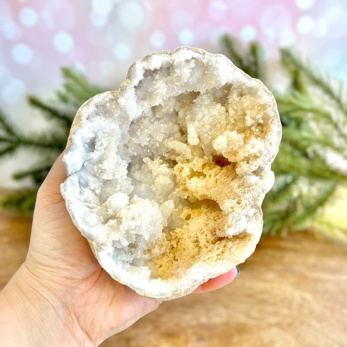 Image of a large Quartz sugar geode from Morocco. Has a sandy beige exterior, and lots of small, white crystals on the inside. Has some pale yellow iron staining on some crystals