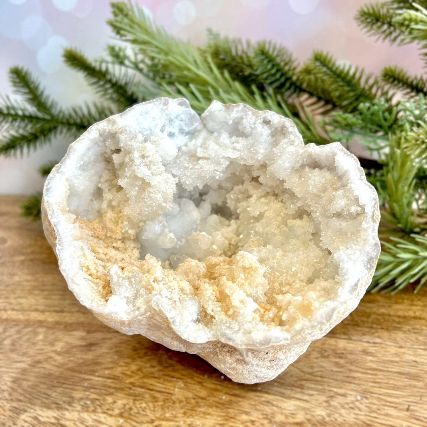 Image of a large Quartz sugar geode from Morocco. Has a sandy beige exterior, and lots of small, white crystals on the inside. Has some pale yellow iron staining on some crystals