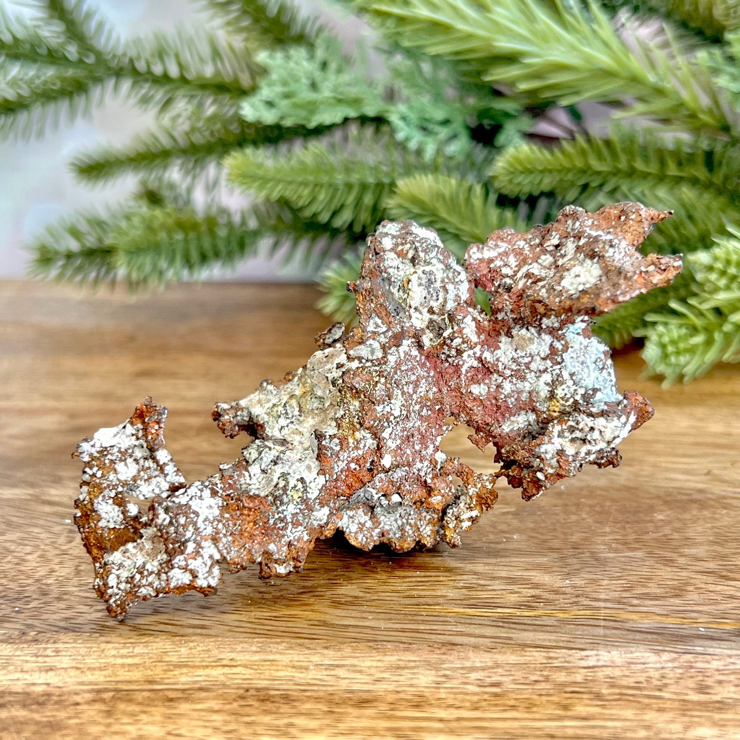 Image of a large native copper mineral specimen from Michigan. Several inches with mossy green verdigris patina on parts. Oxidized, so it's not shiny. Some dendritic formations