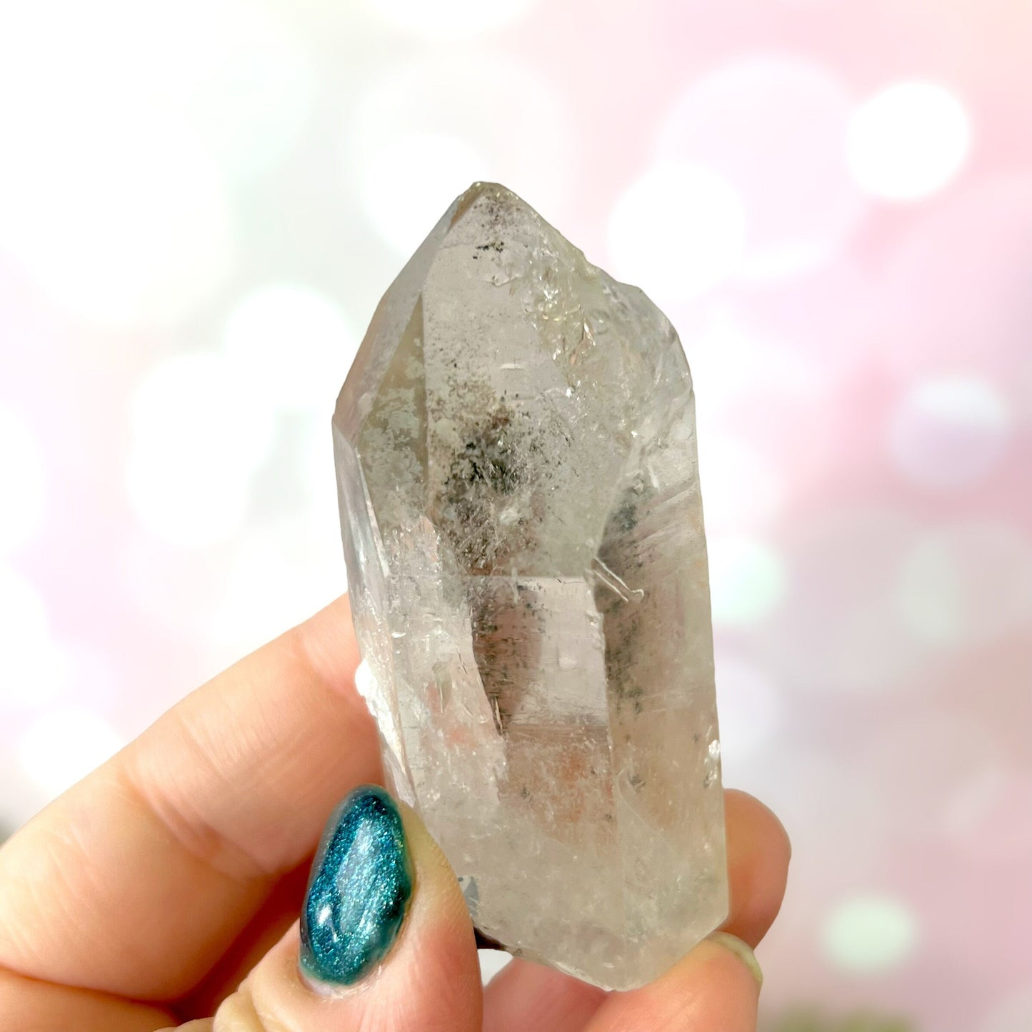 Close up of a small garden Quartz crystal point with chlorite inclusions. This mineral specimen is also called Lodolite, and is natural.