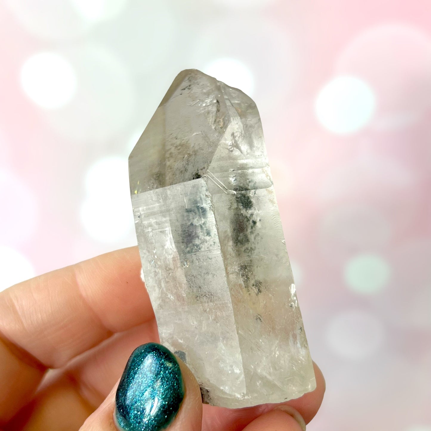 Close up of a small garden Quartz crystal point with chlorite inclusions. This mineral specimen is also called Lodolite, and is natural.
