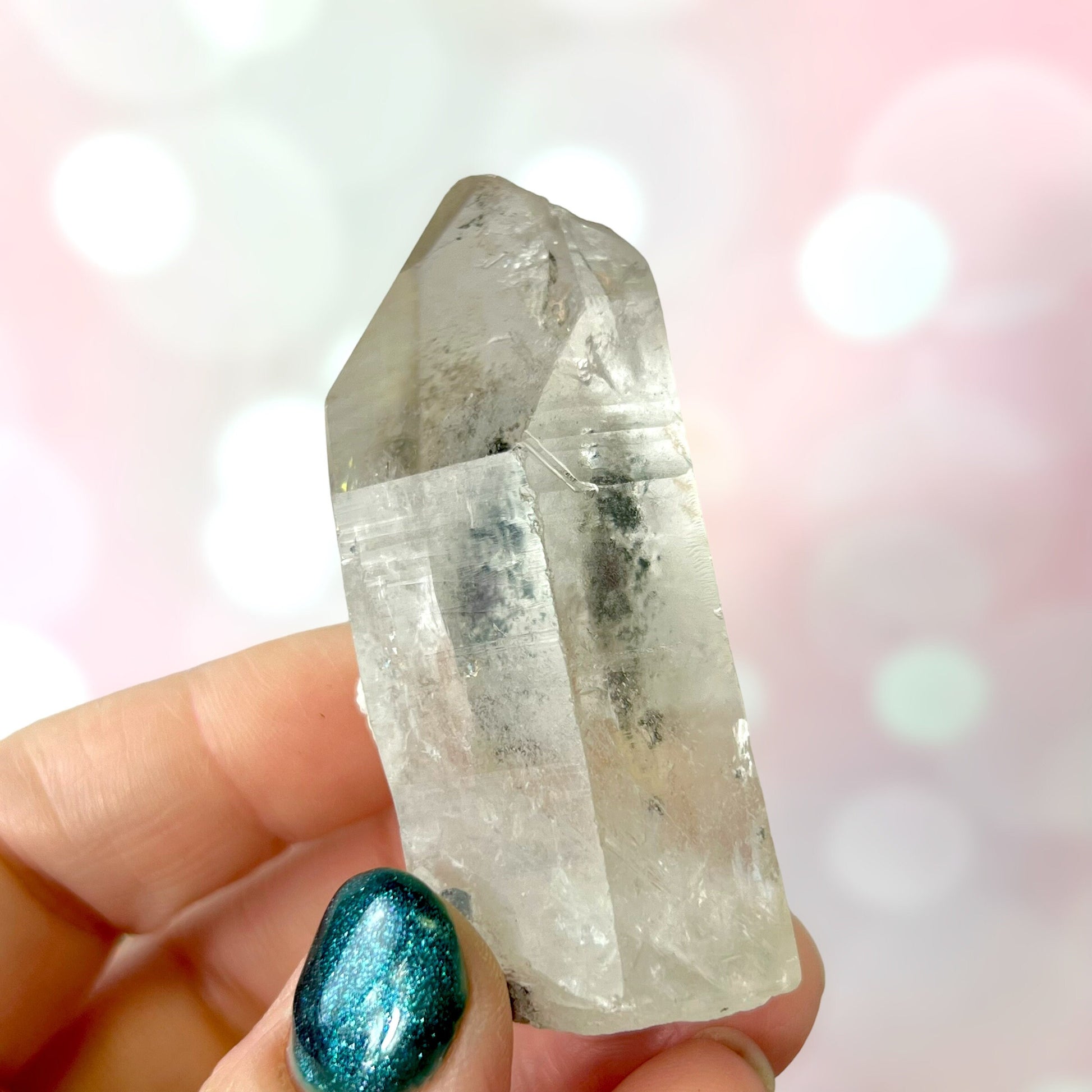 Close up of a small garden Quartz crystal point with chlorite inclusions. This mineral specimen is also called Lodolite, and is natural.