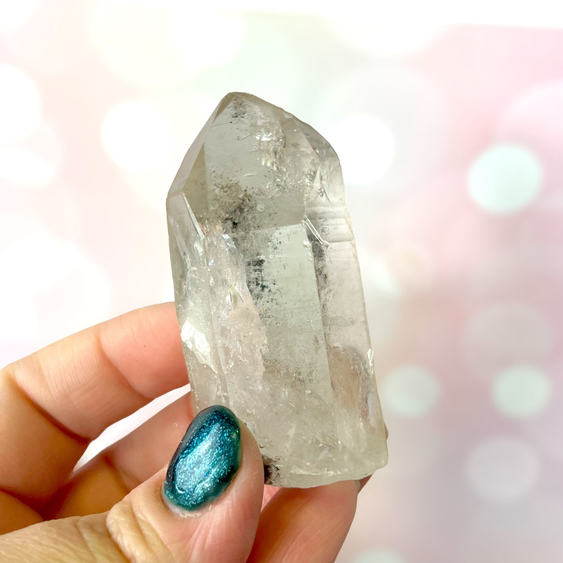 Close up of a small garden Quartz crystal point with chlorite inclusions. This mineral specimen is also called Lodolite, and is natural.