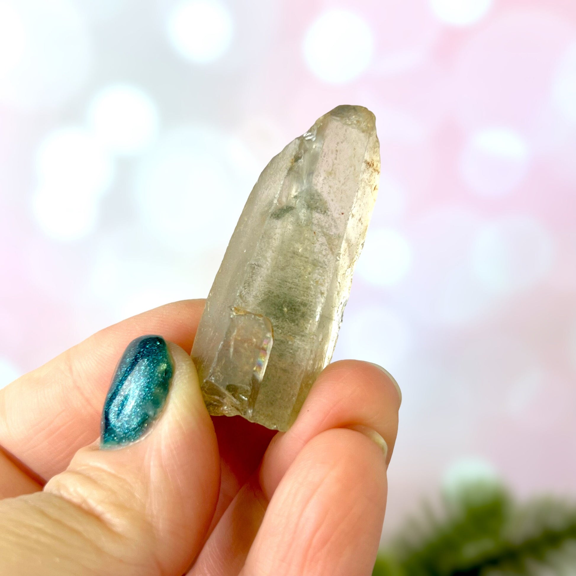 Close up of a small garden Quartz crystal point with chlorite inclusions. This mineral specimen is also called Lodolite, and is natural.