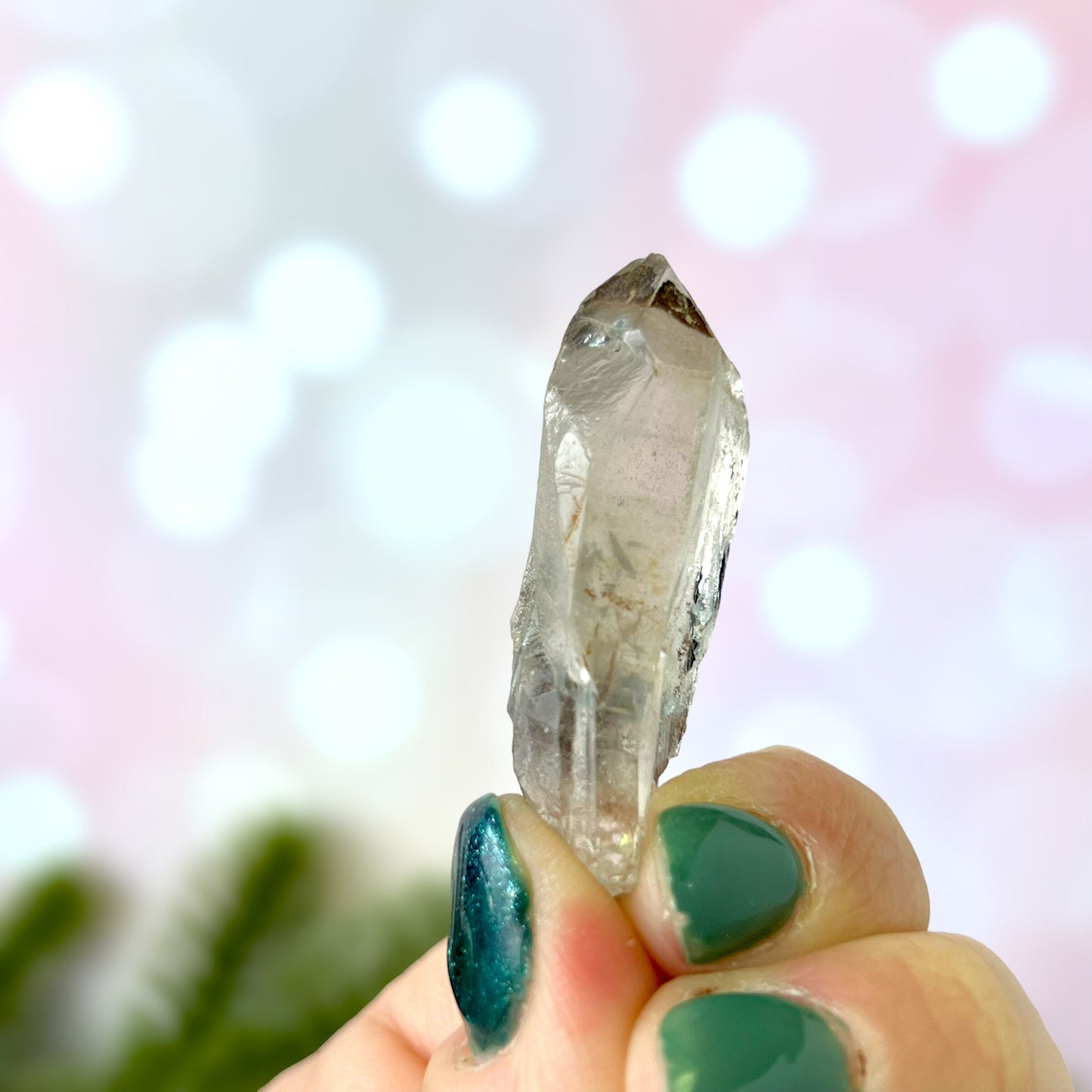 Close up of a small garden Quartz crystal point with chlorite inclusions. This mineral specimen is also called Lodolite, and is natural.