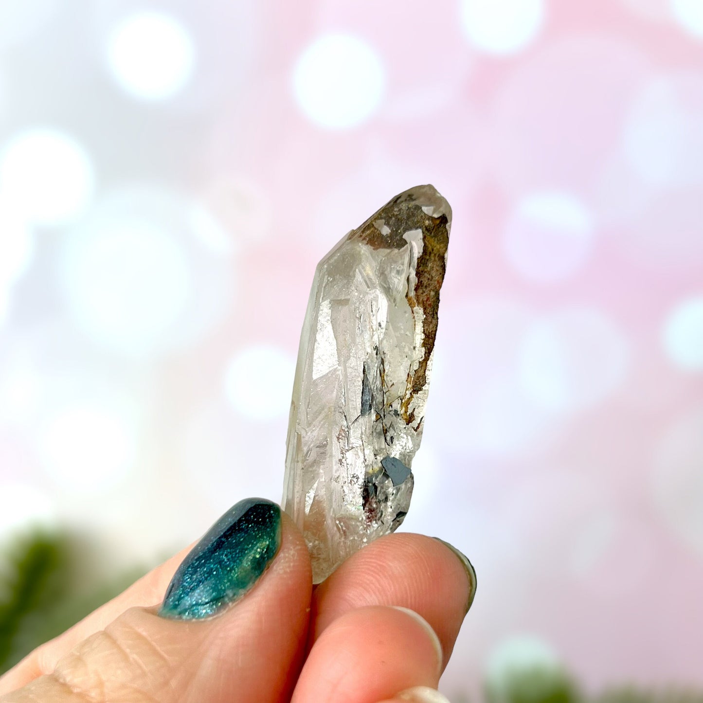Close up of a small garden Quartz crystal point with chlorite inclusions. This mineral specimen is also called Lodolite, and is natural.