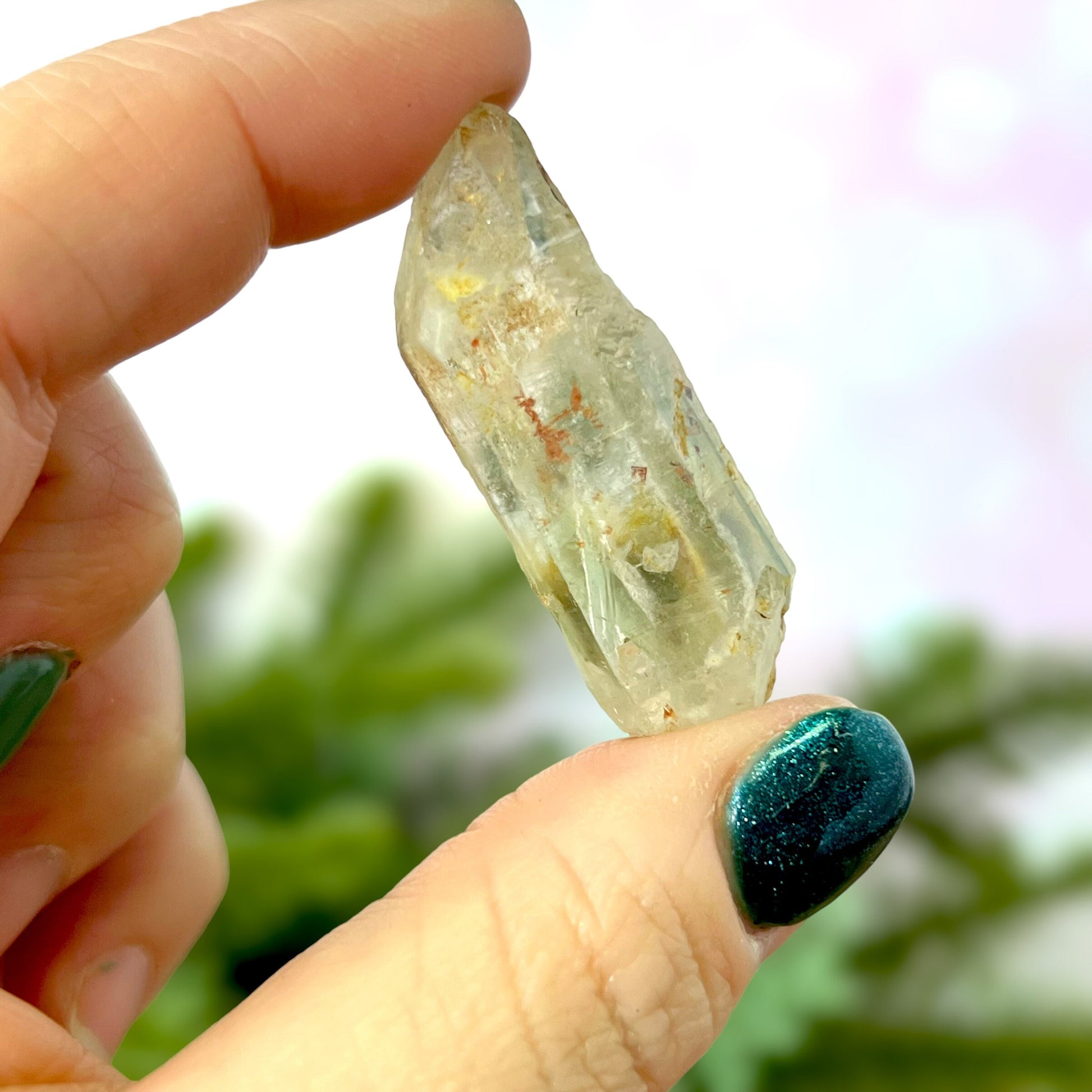Close up of a small garden Quartz crystal point with chlorite inclusions. This mineral specimen is also called Lodolite, and is natural.