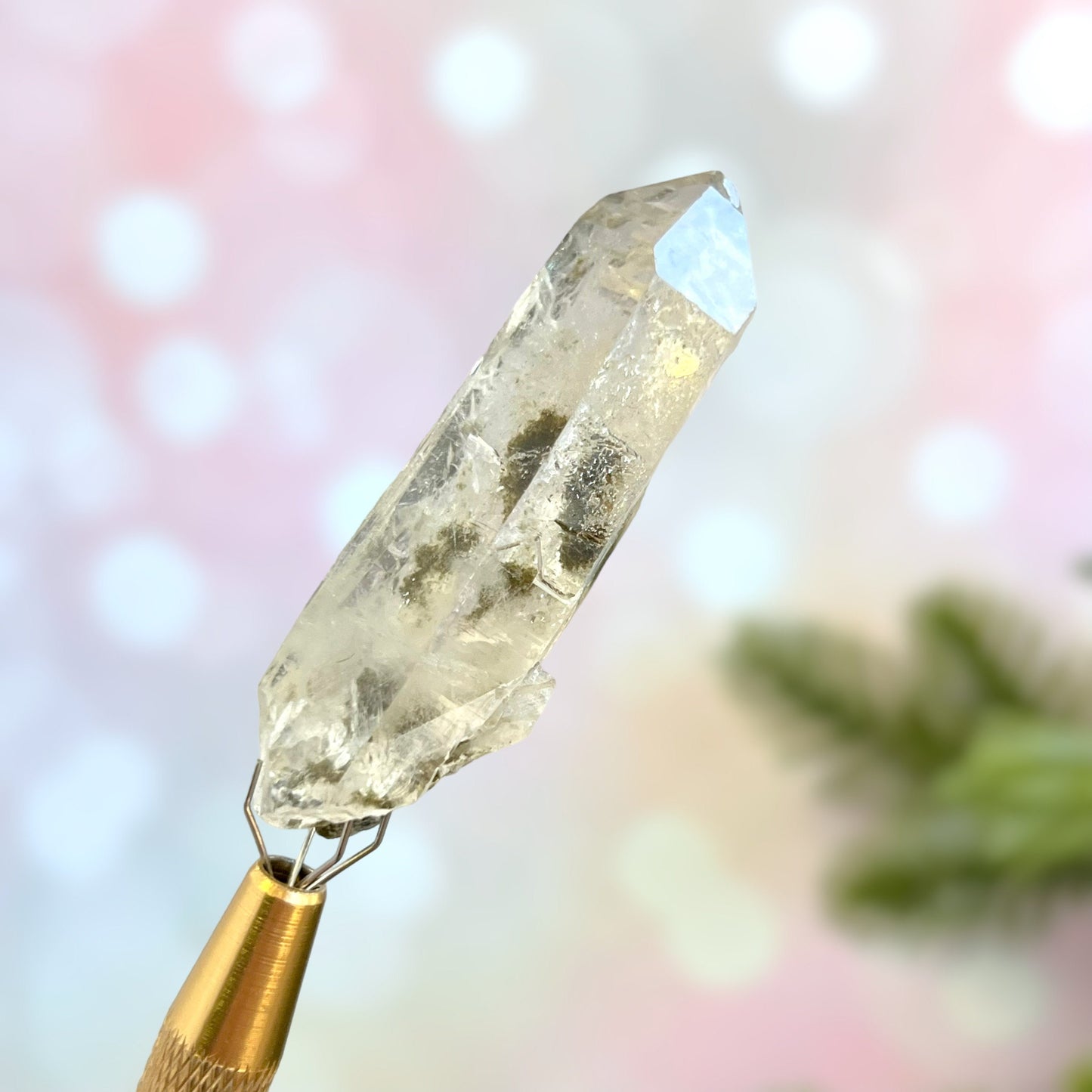 Close up of a small garden Quartz crystal point with chlorite inclusions. This mineral specimen is also called Lodolite, and is natural.