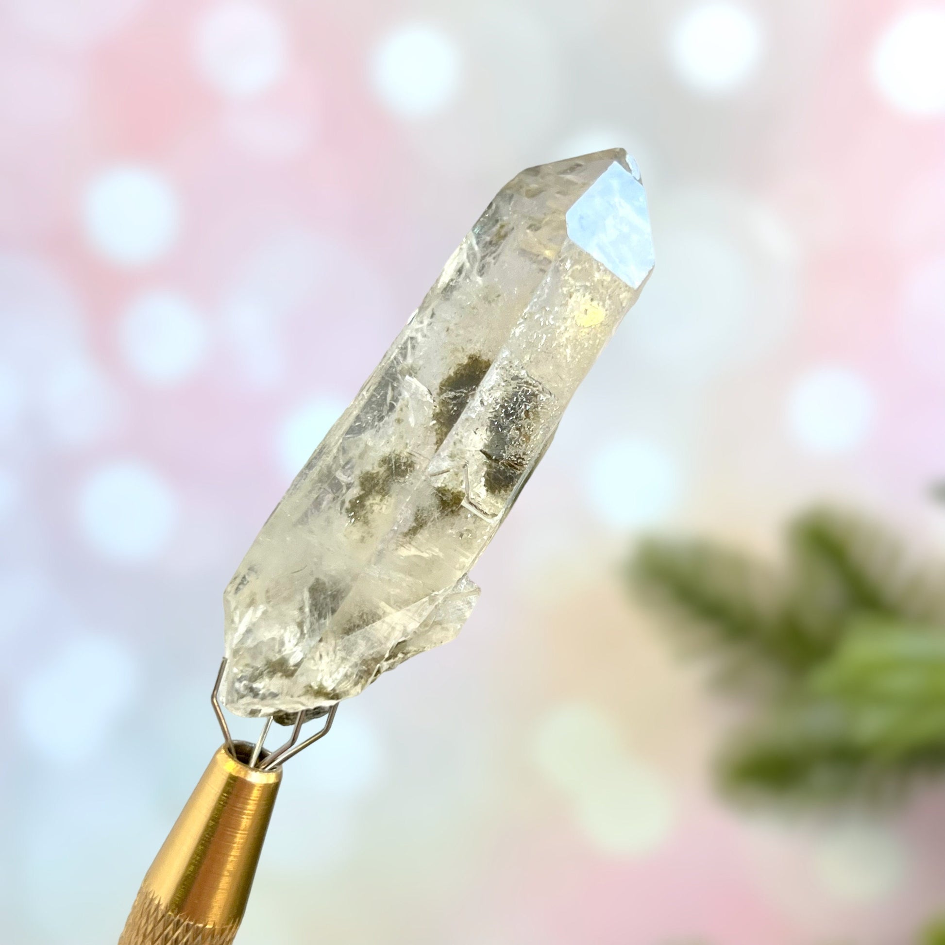 Close up of a small garden Quartz crystal point with chlorite inclusions. This mineral specimen is also called Lodolite, and is natural.