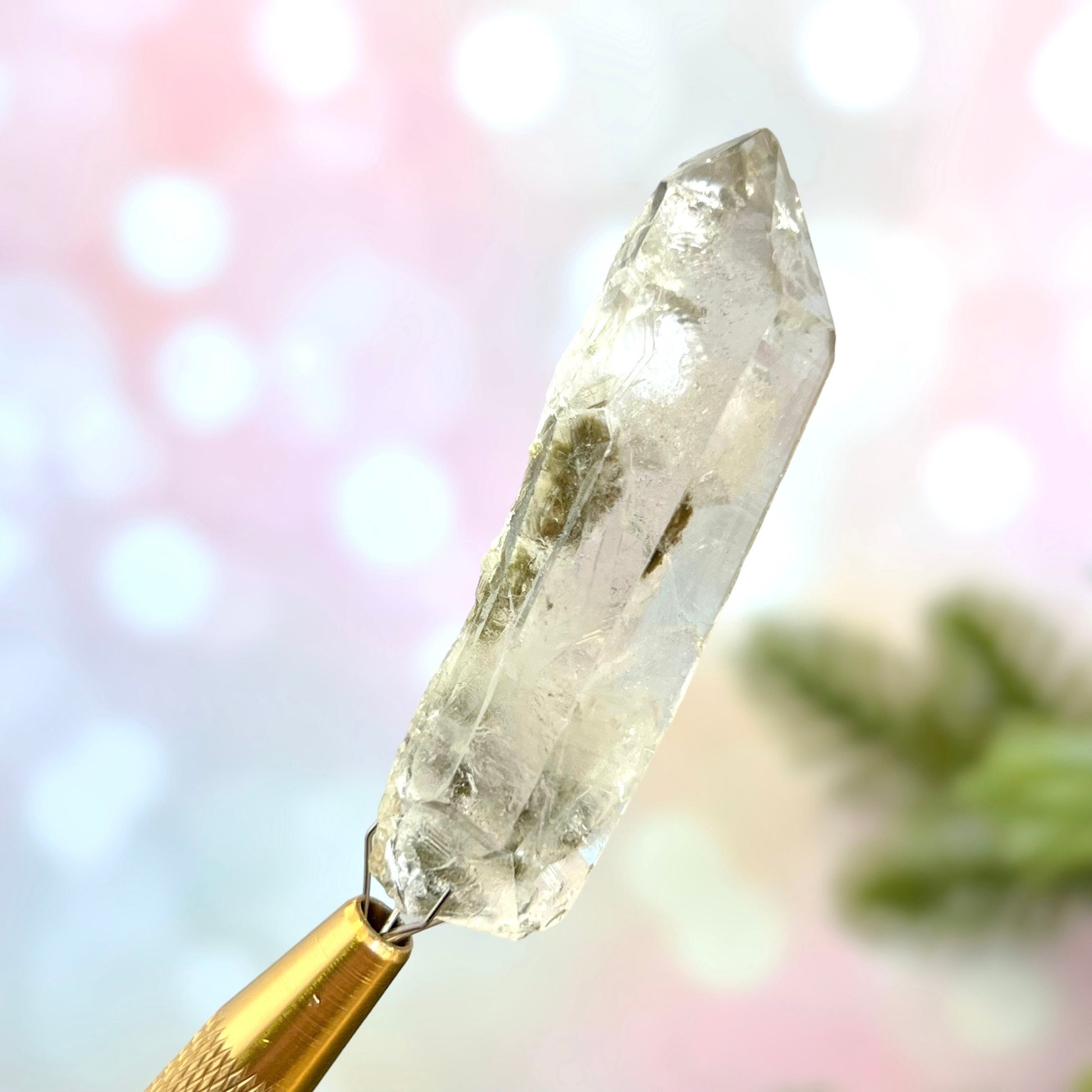 Close up of a small garden Quartz crystal point with chlorite inclusions. This mineral specimen is also called Lodolite, and is natural.