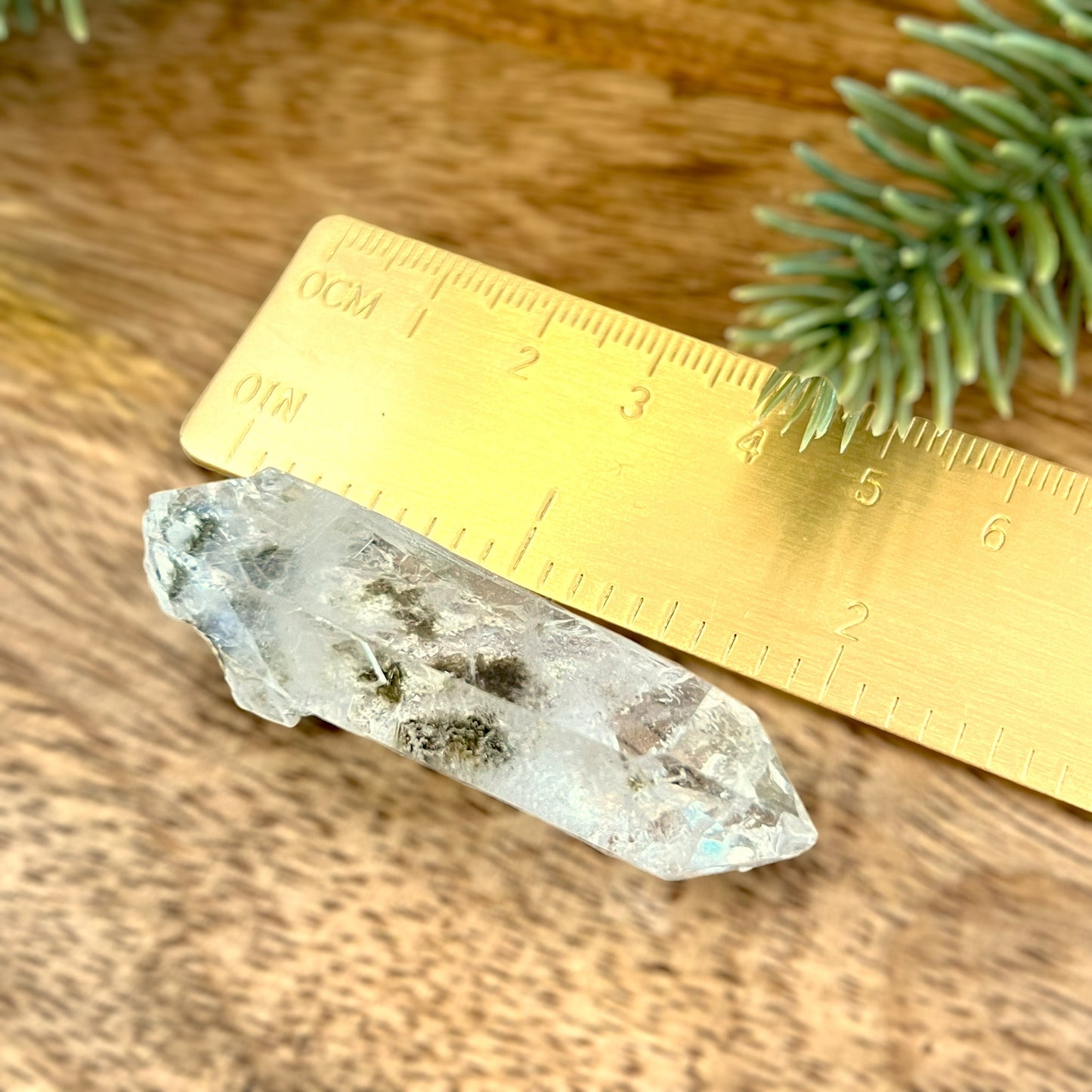 Details of a small garden Quartz crystal point with chlorite inclusions. This mineral specimen is also called Lodolite, and is natural.
