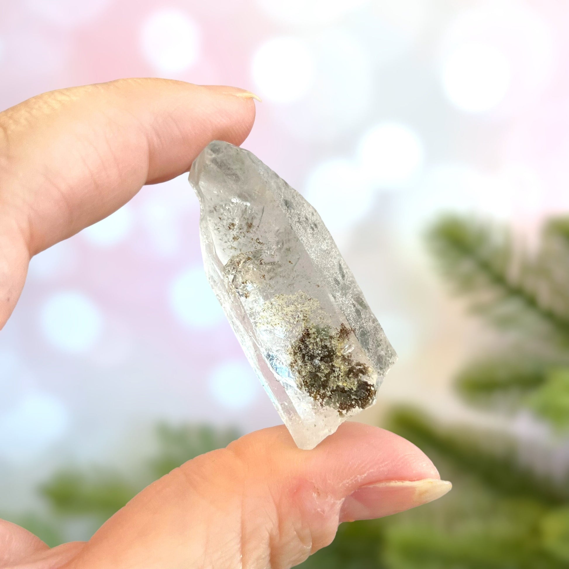 Close up of a small garden Quartz crystal point with chlorite inclusions. This mineral specimen is also called Lodolite, and is natural.