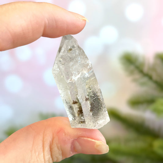 Close up of a small garden Quartz crystal point with chlorite inclusions. This mineral specimen is also called Lodolite, and is natural.