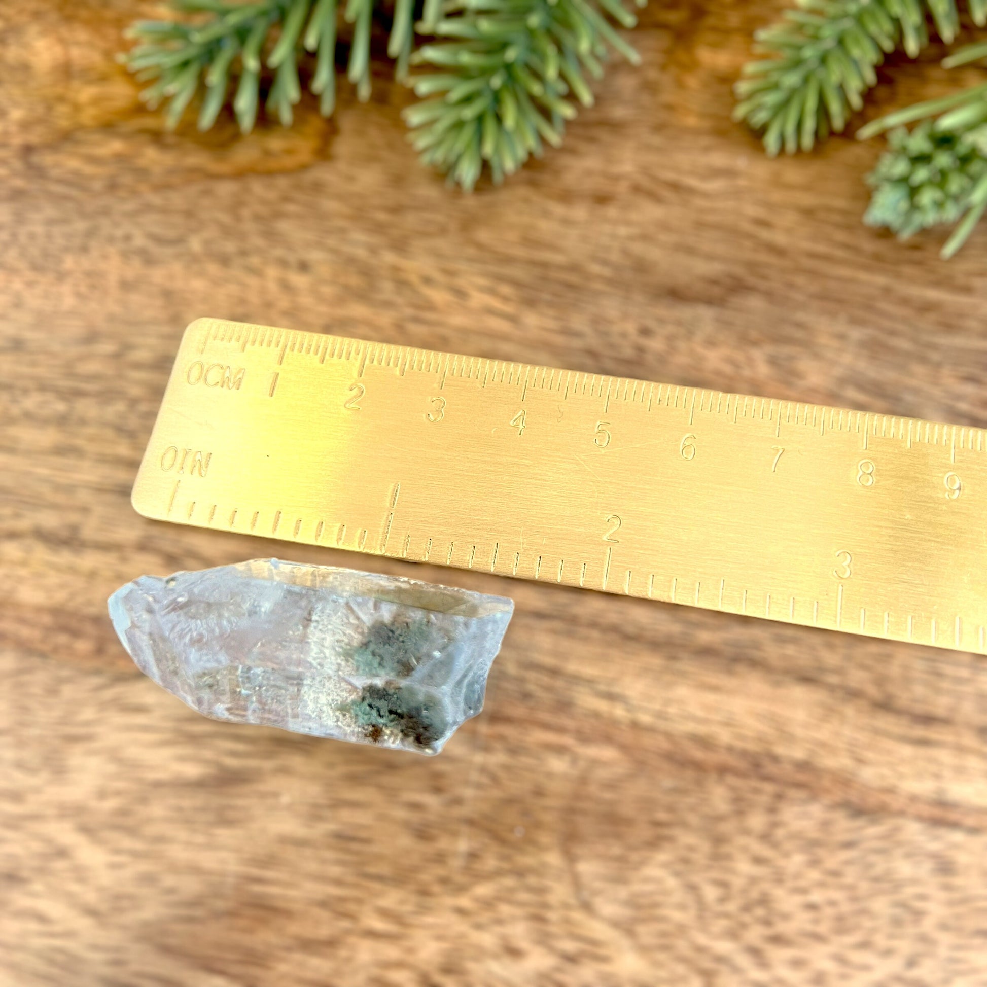 Close up of a small garden Quartz crystal point with chlorite inclusions. This mineral specimen is also called Lodolite, and is natural.
