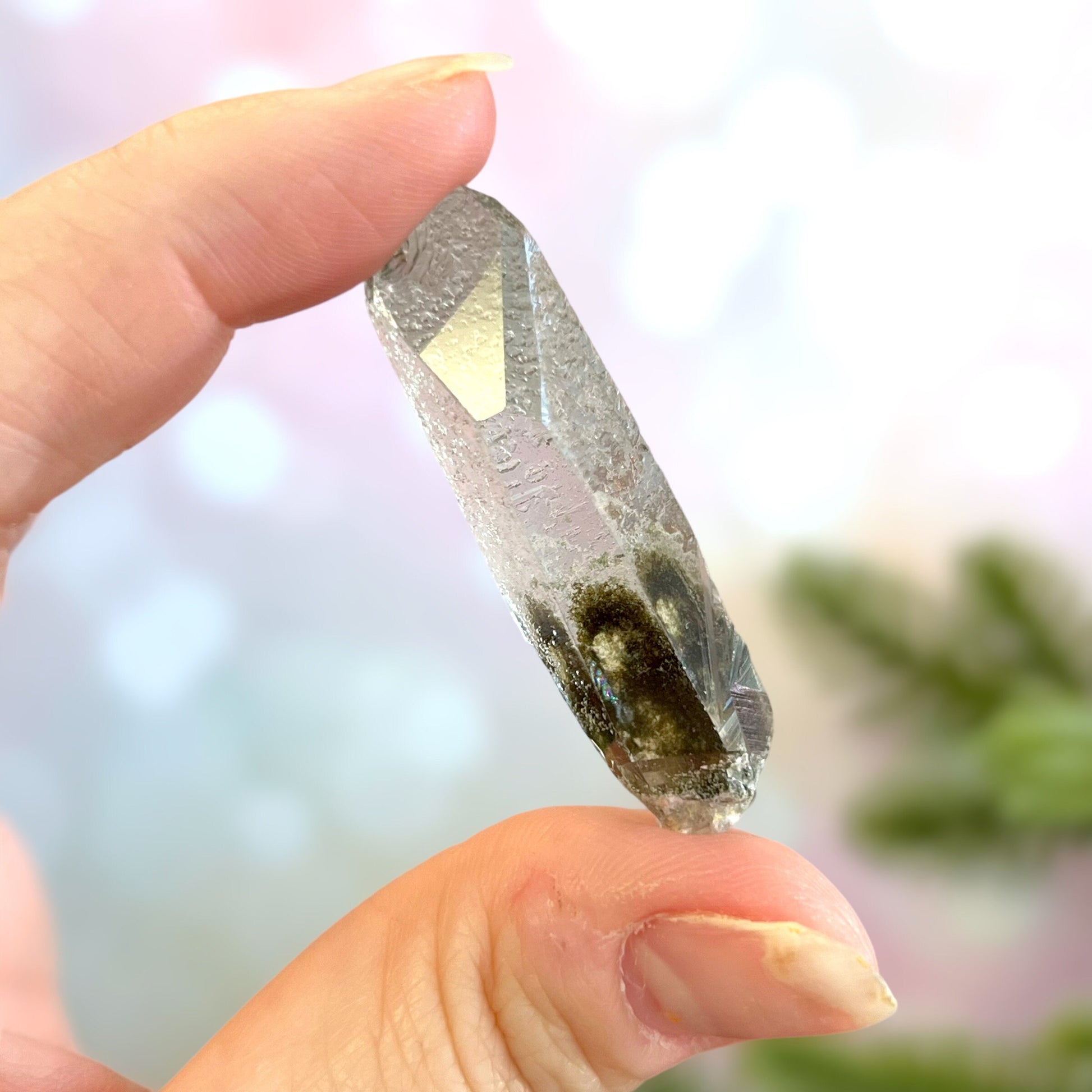Close up of a small garden Quartz crystal point with chlorite inclusions. This mineral specimen is also called Lodolite, and is natural.