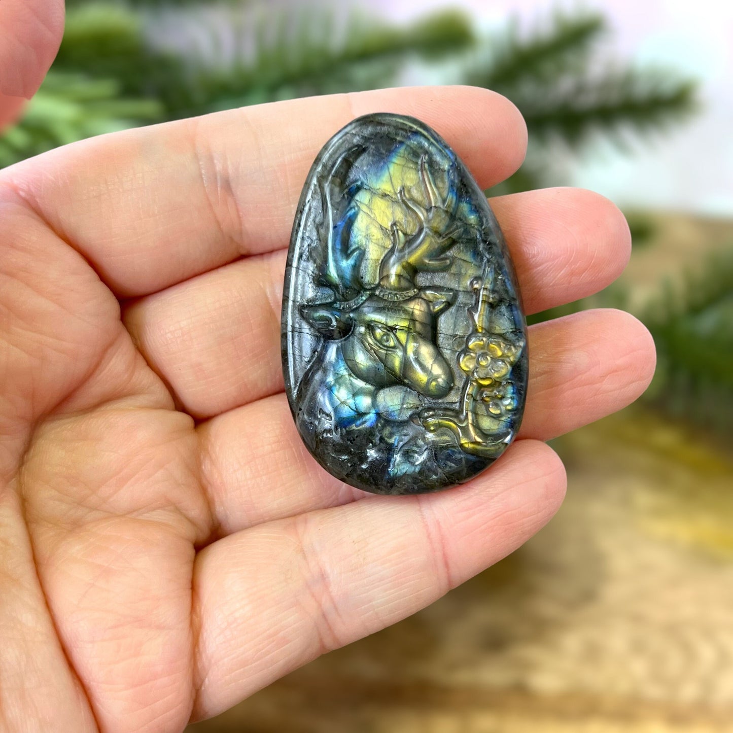 Labradorite Crystal cabochon carved into the shape of an oval teardrop, featuring a stag deer's head
