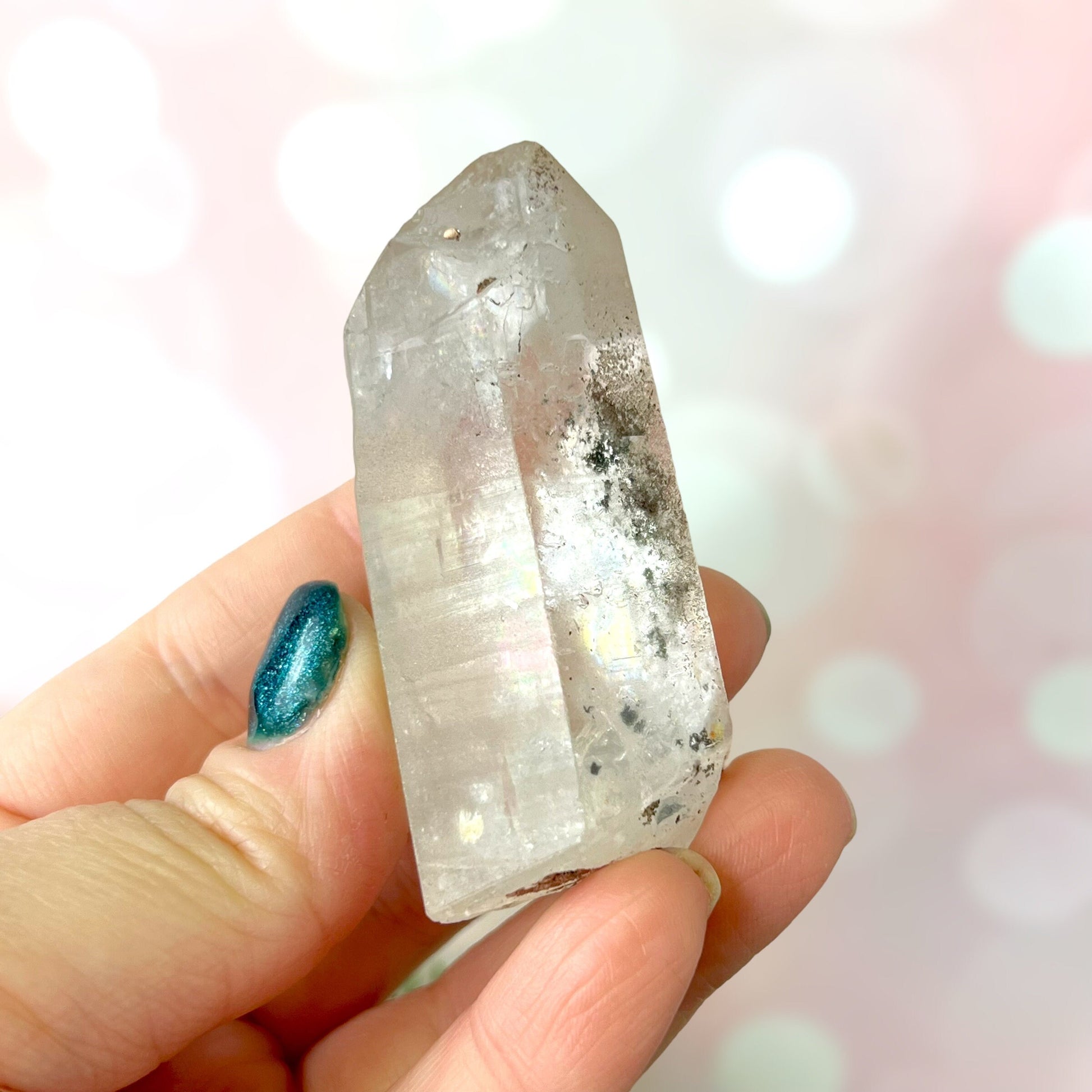 Close up of a small garden Quartz crystal point with chlorite inclusions. This mineral specimen is also called Lodolite, and is natural.