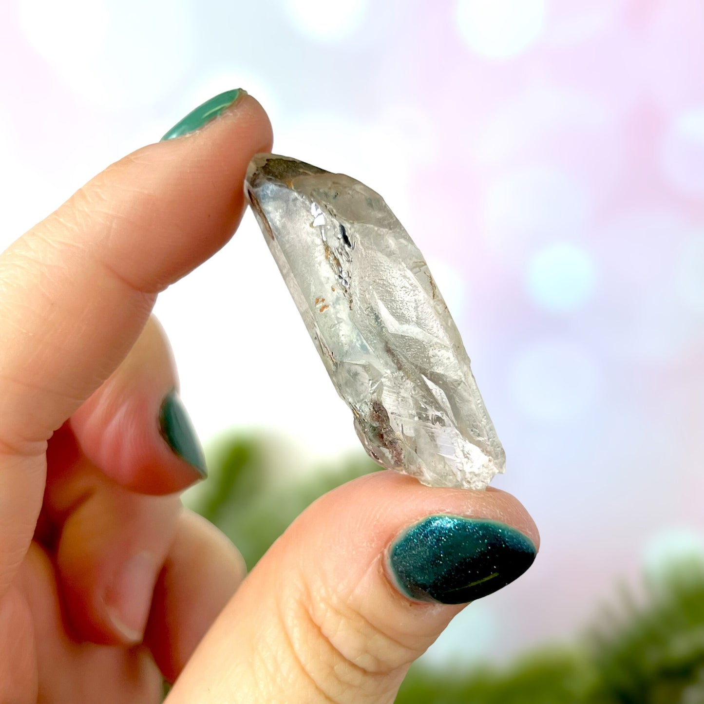 Close up of a small garden Quartz crystal point with chlorite inclusions. This mineral specimen is also called Lodolite, and is natural.