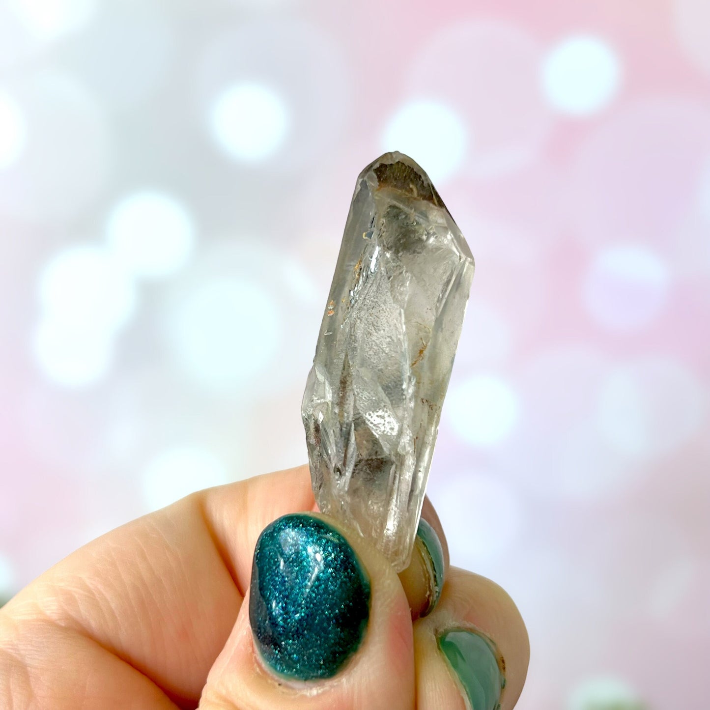 Close up of a small garden Quartz crystal point with chlorite inclusions. This mineral specimen is also called Lodolite, and is natural.