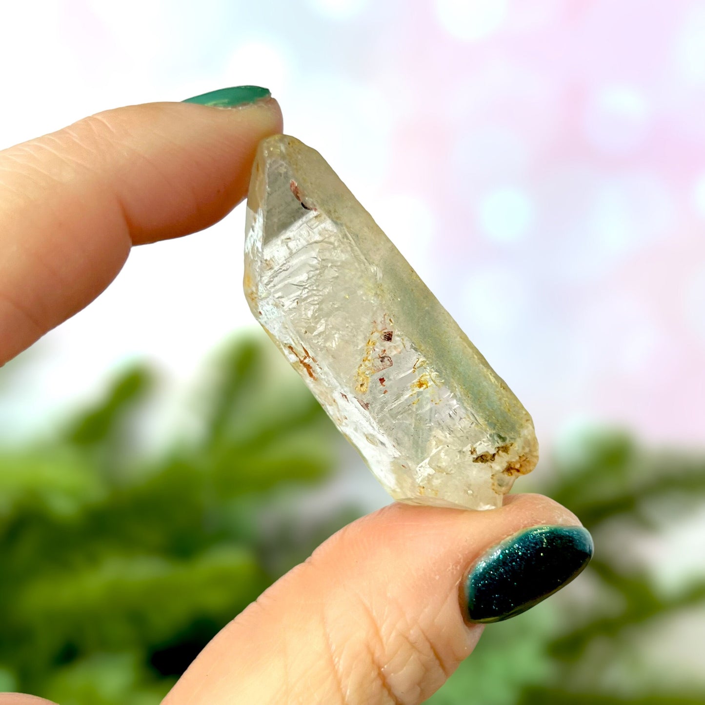 Close up of a small garden Quartz crystal point with chlorite inclusions. This mineral specimen is also called Lodolite, and is natural.