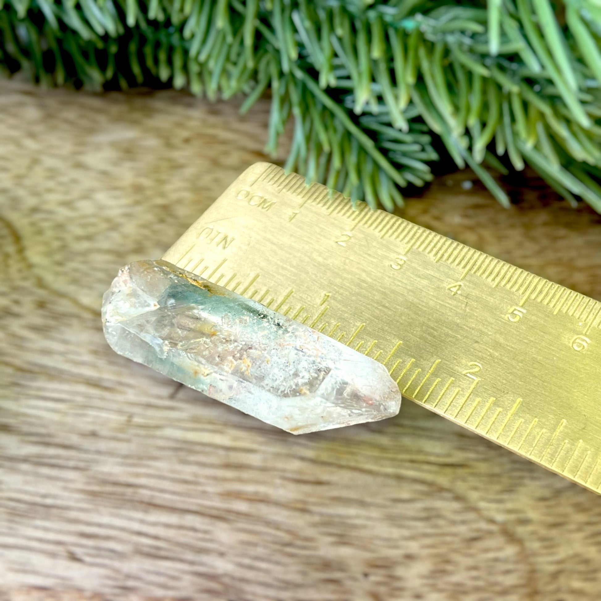 Close up of a small garden Quartz crystal point with chlorite inclusions. This mineral specimen is also called Lodolite, and is natural.