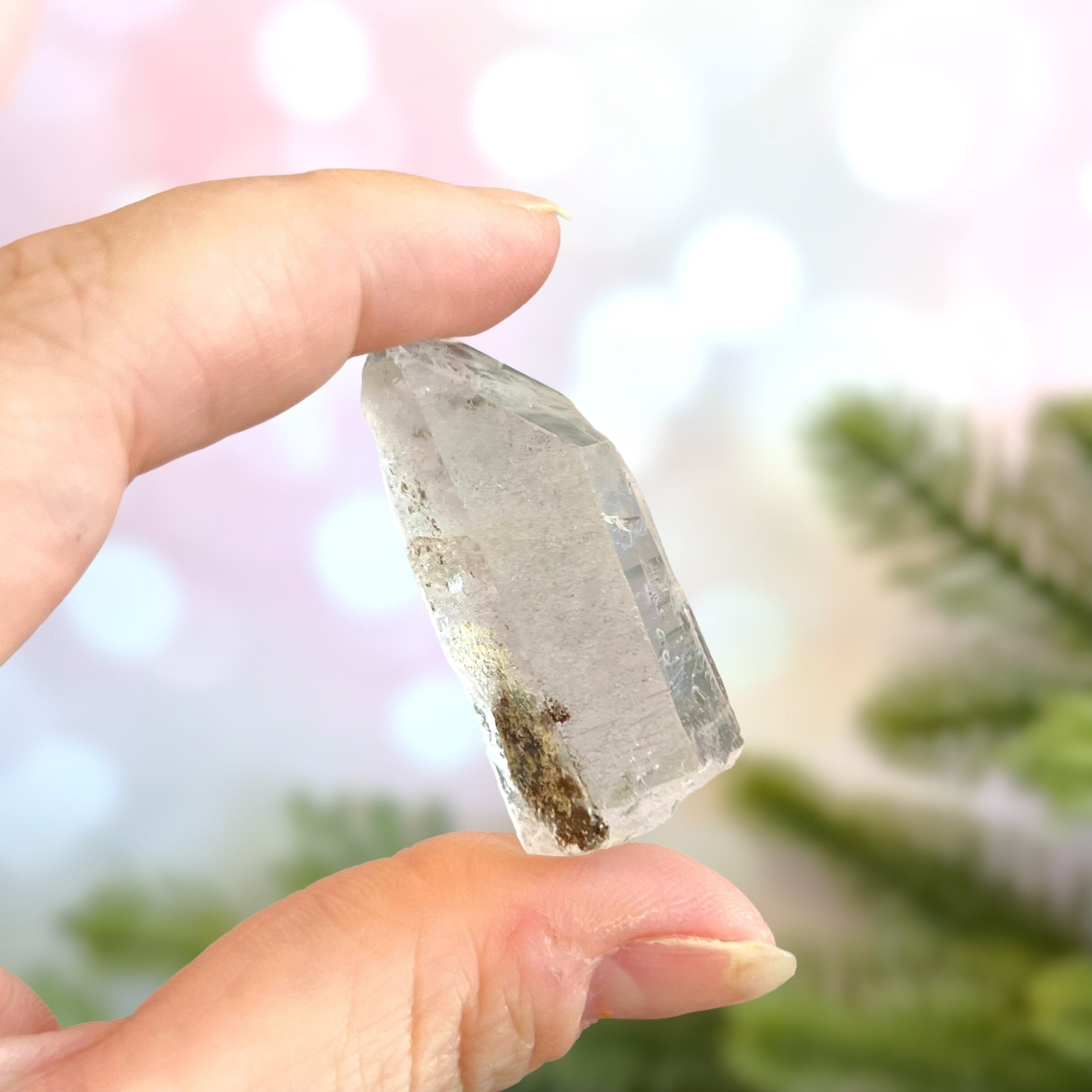 Close up of a small garden Quartz crystal point with chlorite inclusions. This mineral specimen is also called Lodolite, and is natural.