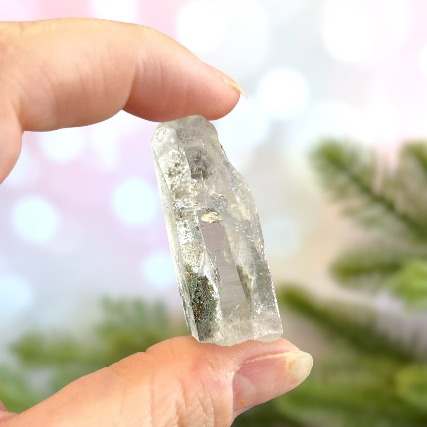 Close up of a small garden Quartz crystal point with chlorite inclusions. This mineral specimen is also called Lodolite, and is natural.