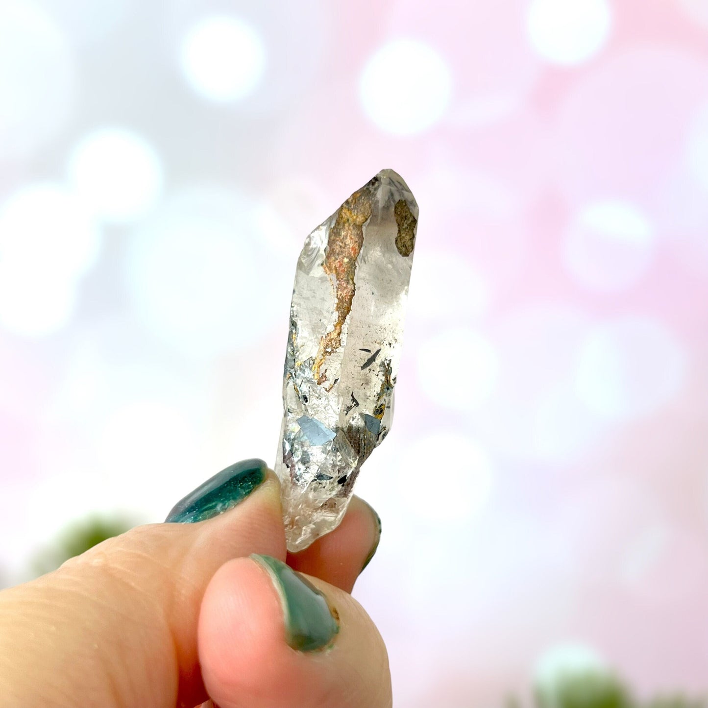 Close up of a small garden Quartz crystal point with chlorite inclusions. This mineral specimen is also called Lodolite, and is natural.