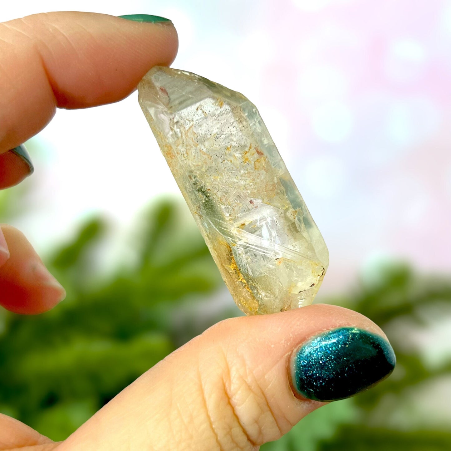 Close up of a small garden Quartz crystal point with chlorite inclusions. This mineral specimen is also called Lodolite, and is natural.