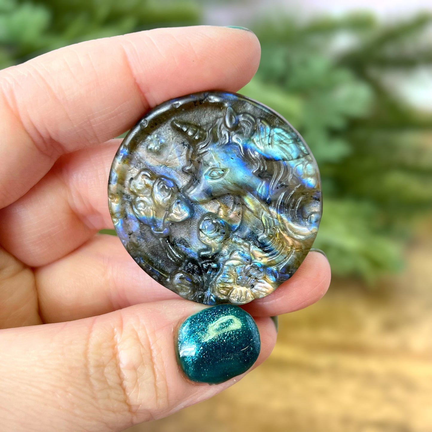 Labradorite Crystal cabochon carved into a circle. Features a unicorn head looking at a butterfly