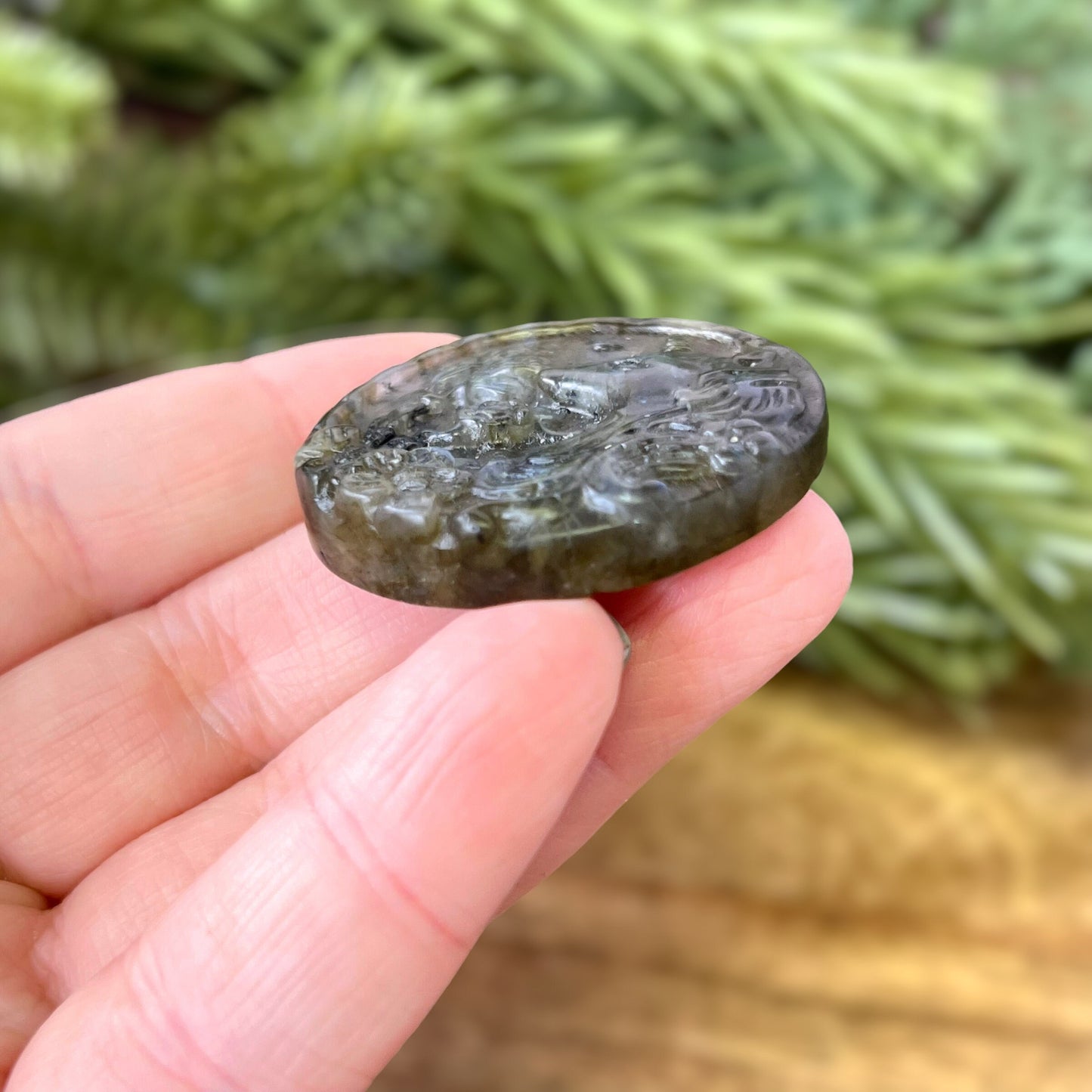 Labradorite Crystal cabochon carved into a circle. Features a unicorn head looking at a butterfly