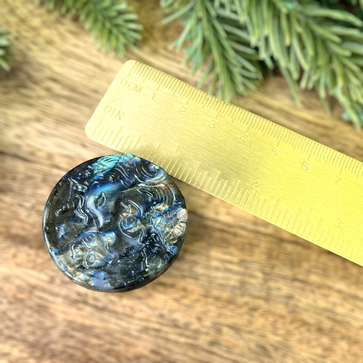 Labradorite Crystal cabochon carved into a circle. Features a unicorn head looking at a butterfly