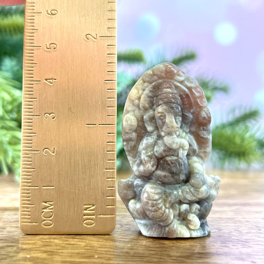 a small buddha statue next to a ruler