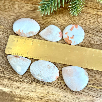 a wooden table topped with white rocks and a ruler