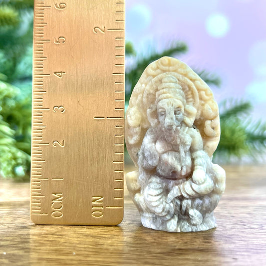 a small statue of an elephant next to a ruler