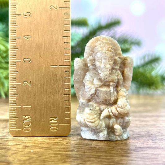 a small statue of an angel next to a ruler