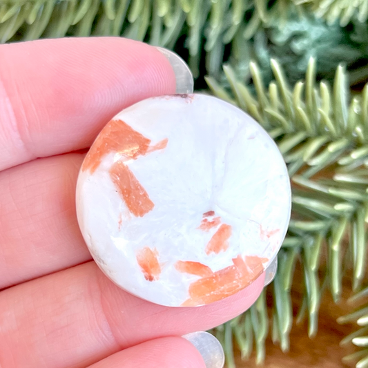 a person holding a piece of white and orange marble