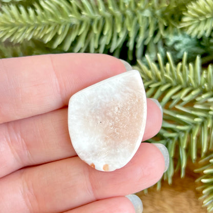 a person holding a piece of white rock in their hand